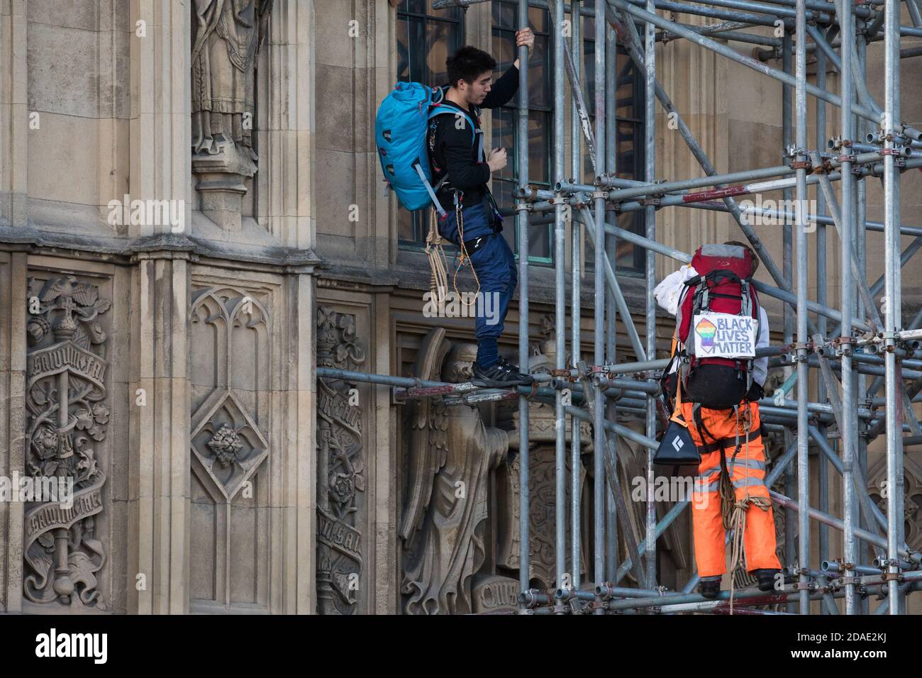 London, UK. 12th November, 2020. Activists from the group Action for Climate Truth and Reparations (ACTR) climb scaffolding to hang an open letter to the UK people from Africans Rising For Justice, Peace and Dignity from the Houses of Parliament. The letter, which launches Africans Rising’s ReRight History campaign, contains a plea to the UK people to start making amends for the harm caused by slavery and colonialism.  Credit: Mark Kerrison/Alamy Live News Stock Photo