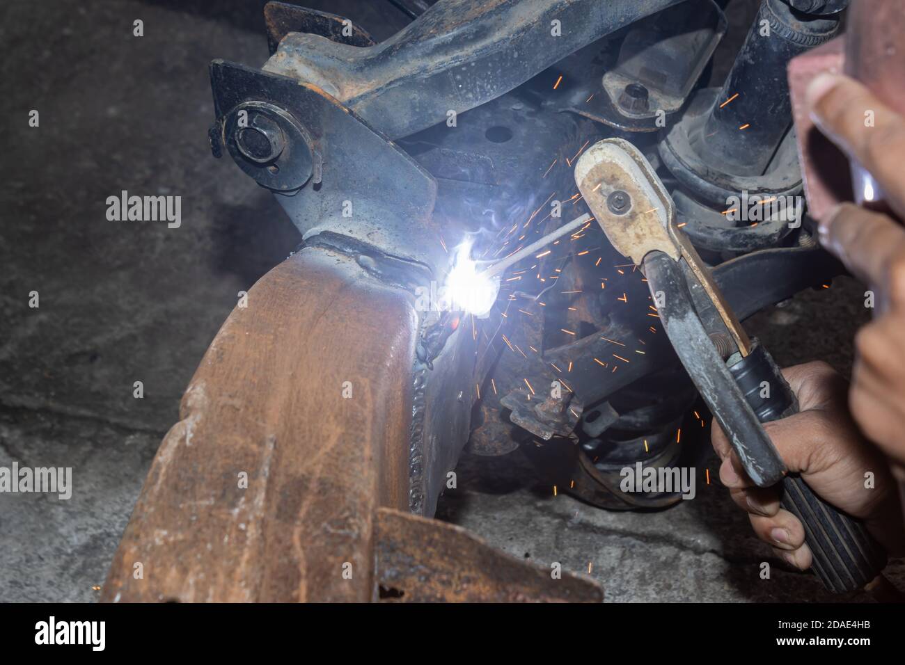 Welder Welding Bottom Car Chassis by Electric Welding Torch at Side View Stock Photo