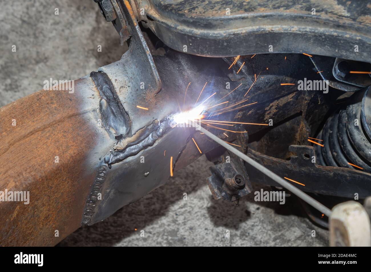 Welder Welding Bottom Car Chassis by Electric Welding Torch on Top Left