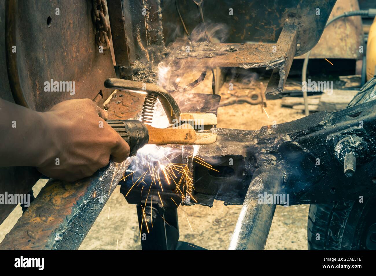 Welder Welding Rear Car Chassis by Electrode Arc Welding Technique by Torch in Vintage Tone Stock Photo