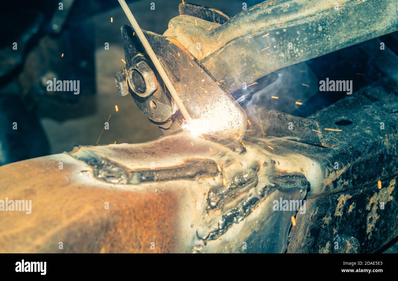 Electrode Arc Welding by Welder at Bottom Car Chassis Area in Zoom View in Vintage Tone Stock Photo