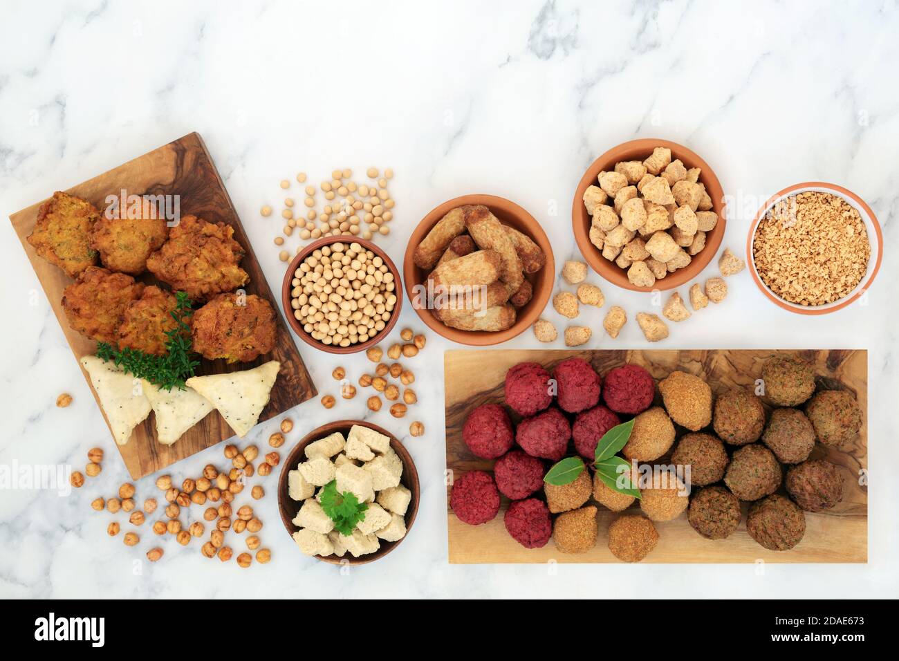 Healthy plant based food for a vegan diet with a variety of tofu balls & sausages, onion bhajis, samosas, soybeans, tvp & bean curd. Ethical eating. Stock Photo