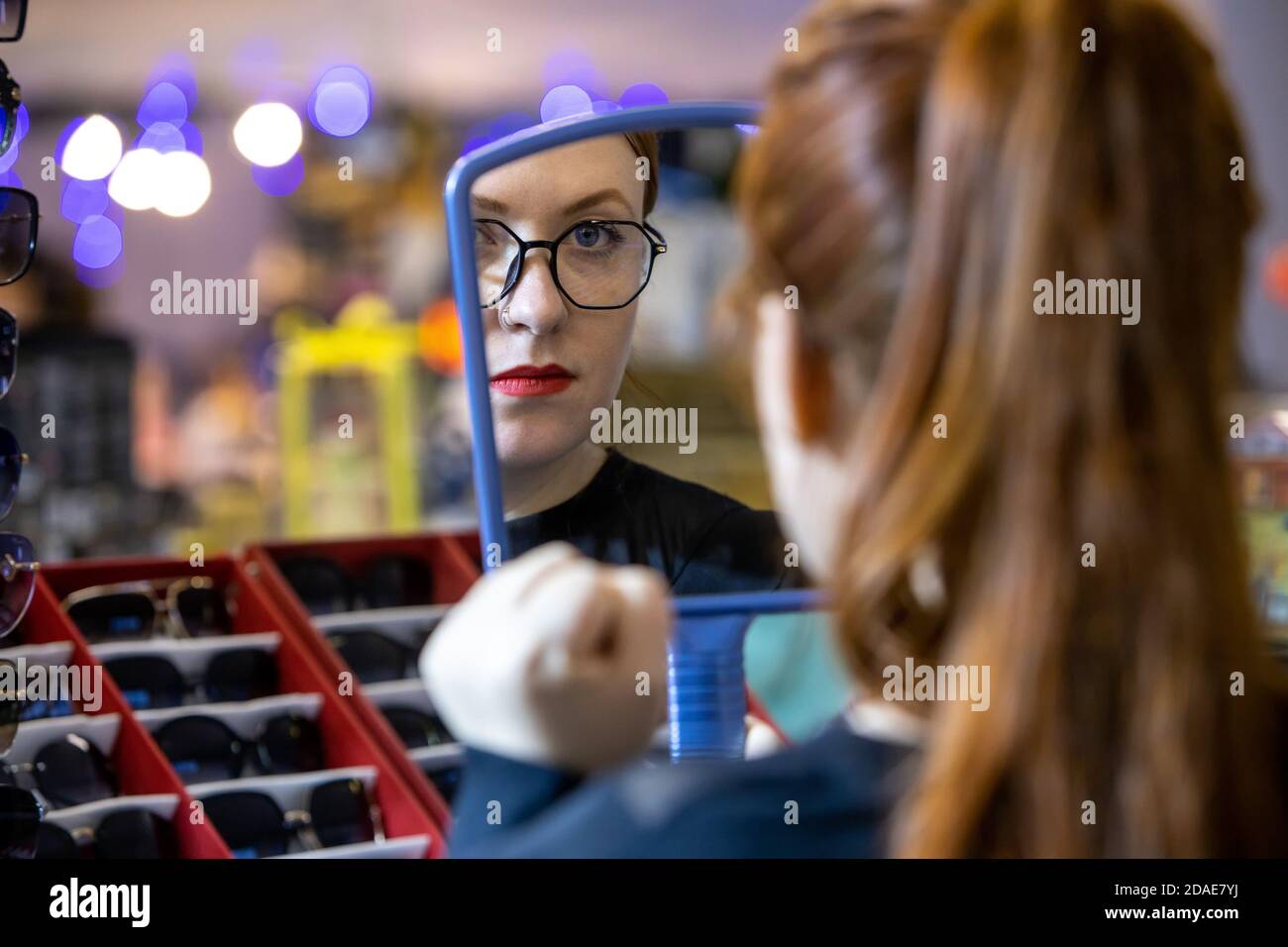 Woman trying on glasses in optical store: Russia. Moscow 20 December 2019 Stock Photo