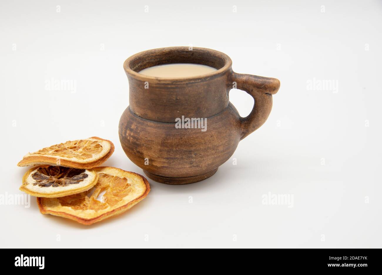 Brown mug and dried oranges on a white background. Stock Photo