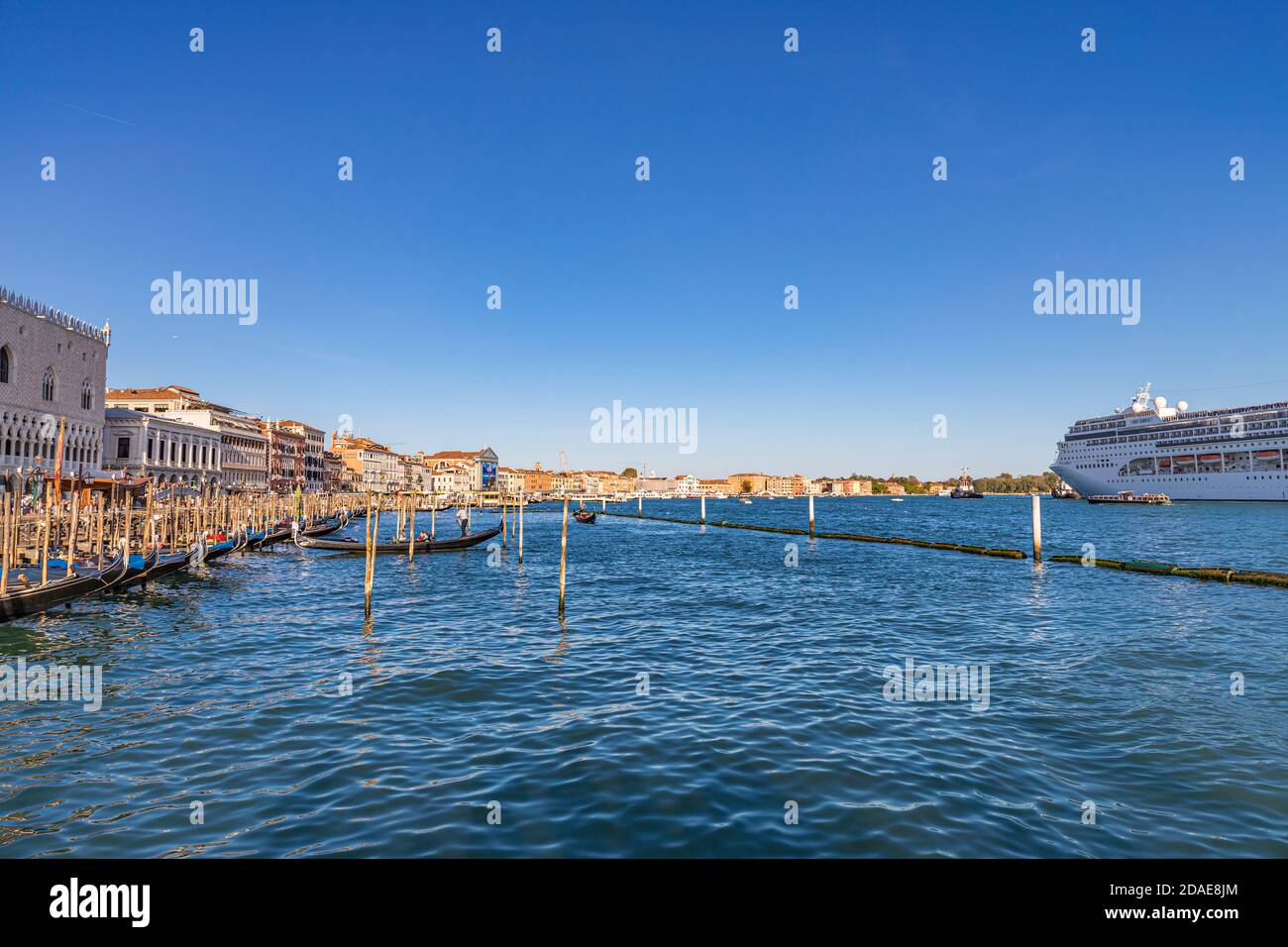 Venice, Italy - 09.11.19: Gondola & huge cruise ship in Giudecca Canal. Many people affirm that the environmental impact of big cruise ships Stock Photo