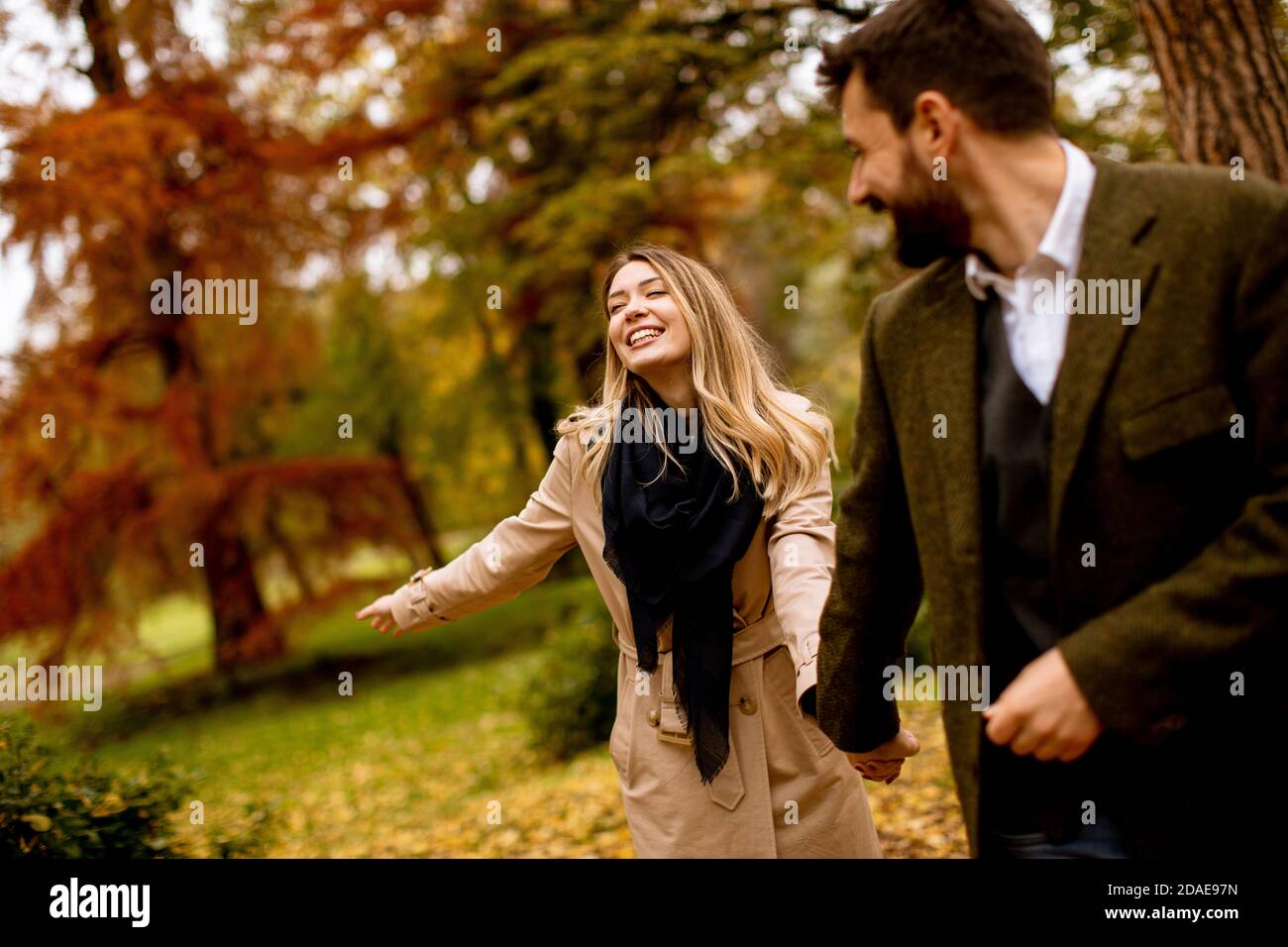 Handsome young couple walking in the autumn park Stock Photo - Alamy