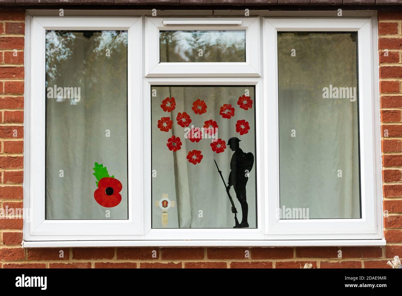 Window decorated for remembrance day with poppies and a soldier silhouette, commemorating armistice during the 2020 coronavirus covid-19 pandemic, UK Stock Photo