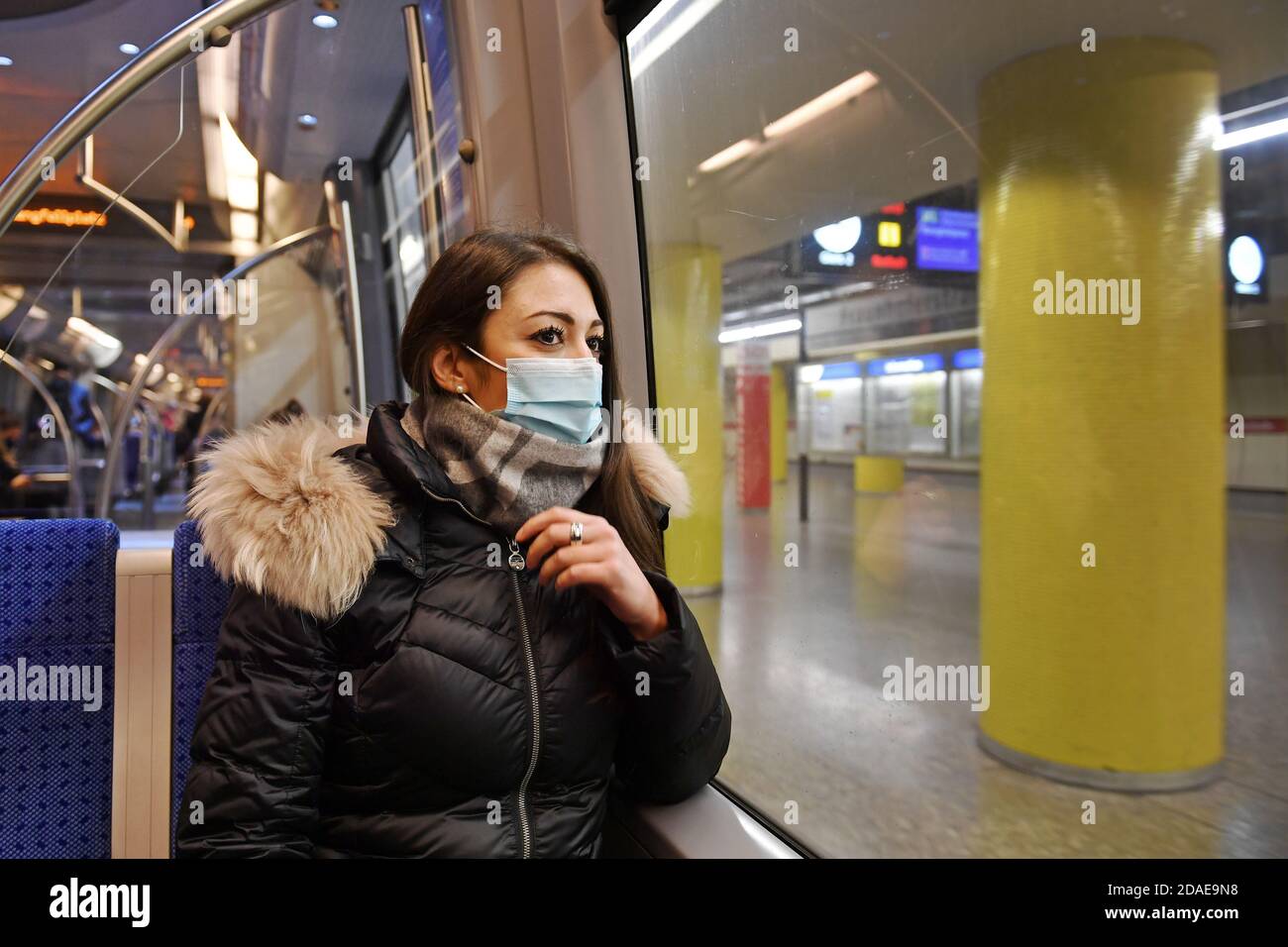 Mask compulsory in public transport. Young woman sitting in a train of the MVG with face mask, mask. U-Bahn Muenchen on November 11th, 2020. OEPNV, public transport, local transport, MVG, metro. MODEL RELEASED! | usage worldwide Stock Photo