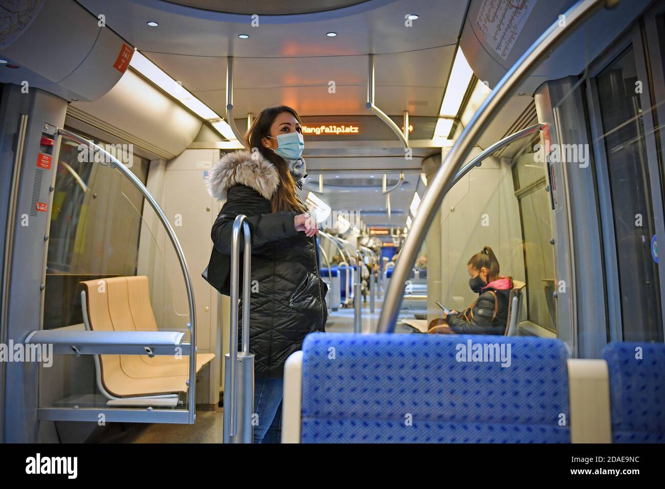 Mask compulsory in public transport. Young woman stands in an almost empty MVG train with face mask, mask. U-Bahn Muenchen on November 11th, 2020. OEPNV, public transport, local transport, MVG, metro. MODEL RELEASED! | usage worldwide Stock Photo