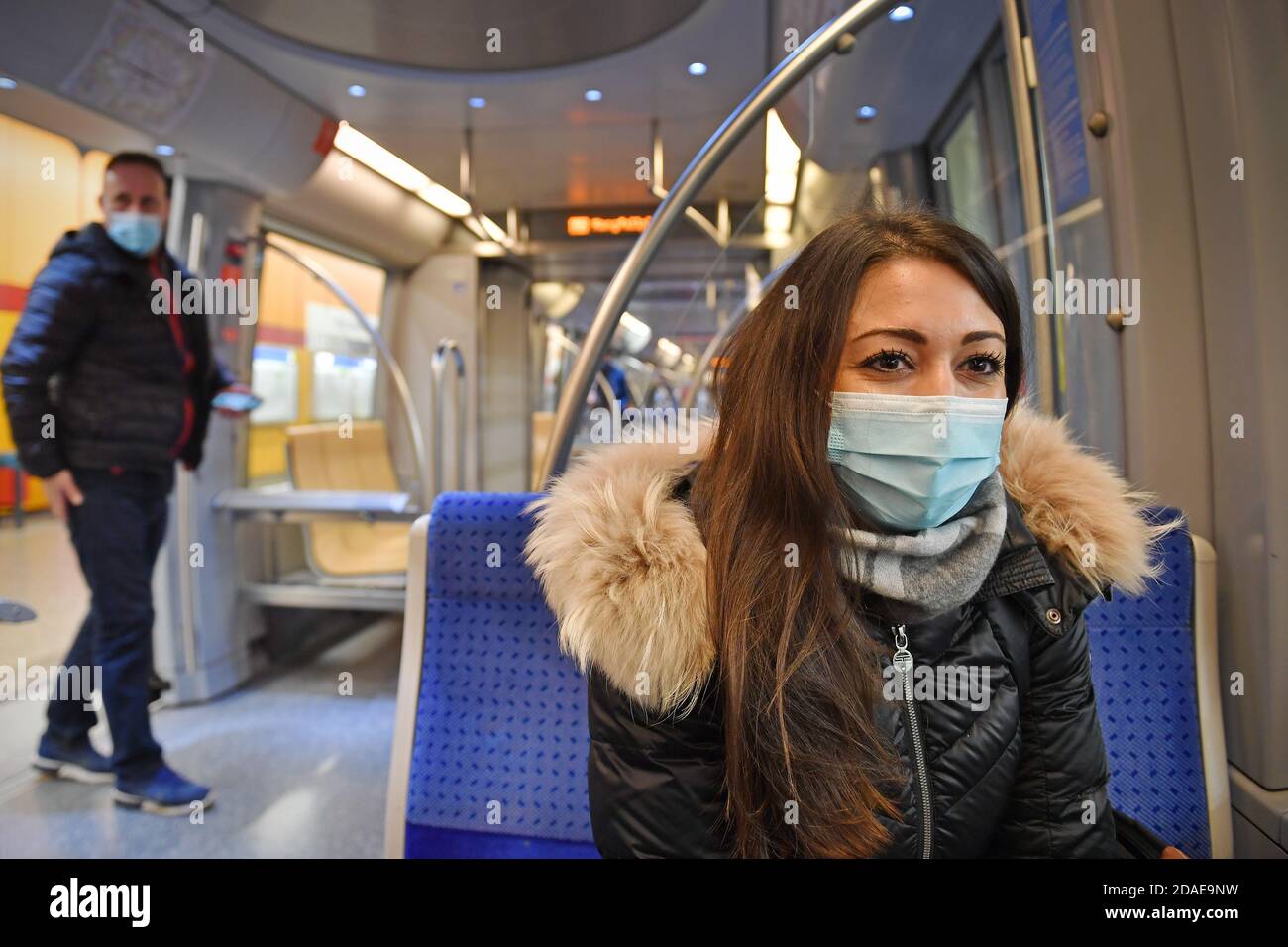 Mask compulsory in public transport. Young woman sitting in a train of the MVG with face mask, mask. U-Bahn Muenchen on November 11th, 2020. OEPNV, public transport, local transport, MVG, metro. MODEL RELEASED! | usage worldwide Stock Photo