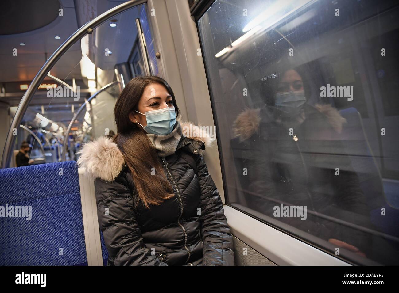 Mask compulsory in public transport. Young woman sitting in a train of the MVG with face mask, mask. U-Bahn Muenchen on November 11th, 2020. OEPNV, public transport, local transport, MVG, metro. MODEL RELEASED! | usage worldwide Stock Photo