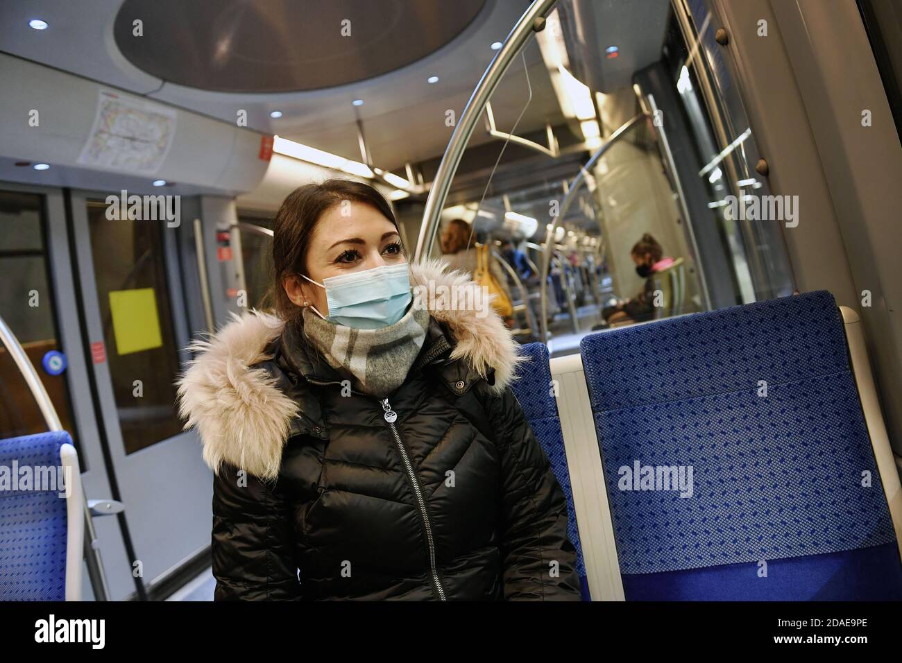 Mask compulsory in public transport. Young woman sitting in a train of the MVG with face mask, mask. U-Bahn Muenchen on November 11th, 2020. OEPNV, public transport, local transport, MVG, metro. MODEL RELEASED! | usage worldwide Stock Photo