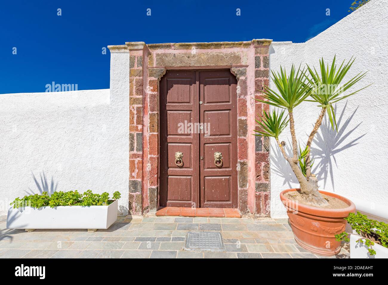 Old wooden door with white architecture in Santorini Greece. Sunny summer weather, vacation, Europe traveling destination, relax, background Stock Photo