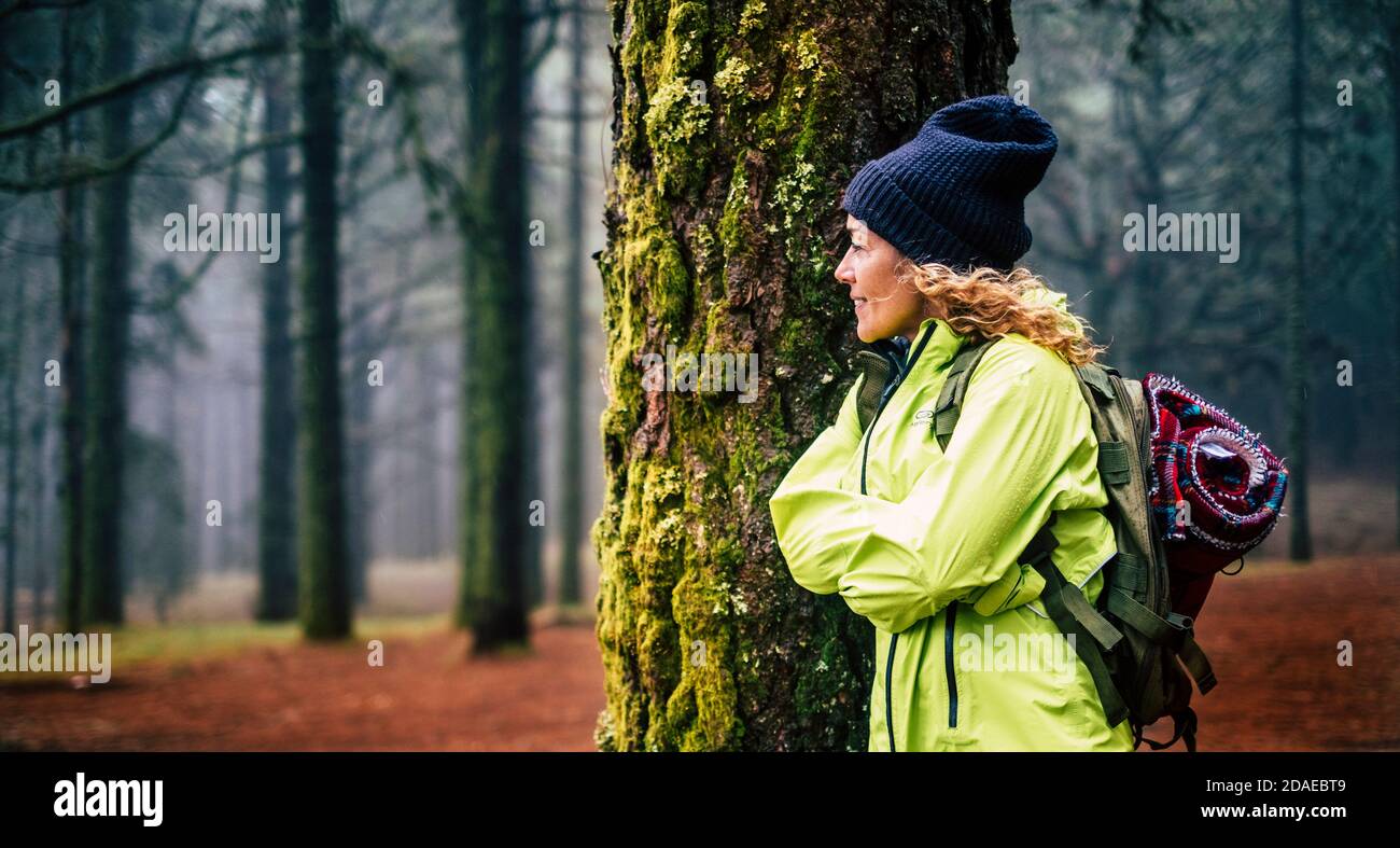 Beautiful woman enjoy the forest wood in outdoor leisure activity - backpack travel and adventure lifestyle - autumn season people enjoying nature and healthy life in a foggy outdoors Stock Photo
