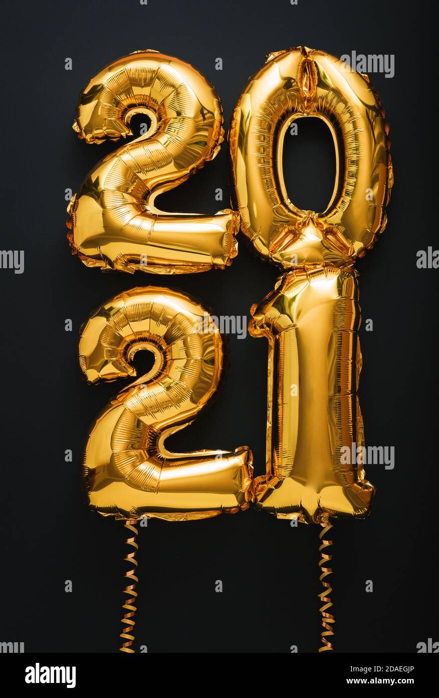 2021 air balloon gold text with ribbons on black background. Happy New year eve invitation with Christmas gold foil balloons 2021. vertical. Stock Photo
