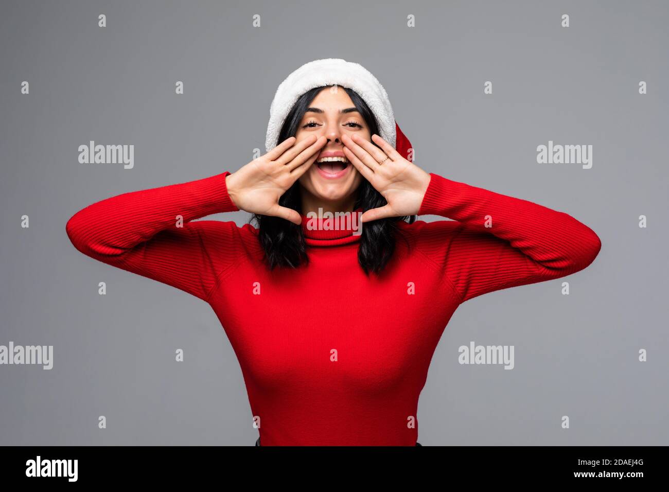 Closeup portrait of a cute Christmas woman with a red Santa Claus hat ...