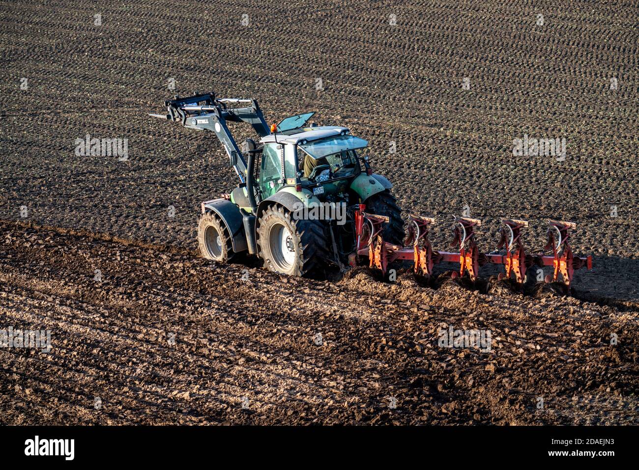 Landwirt pflügt einen Acker, Trecker mit Pflug, bei  Neuss, NRW, Deutschland, Stock Photo
