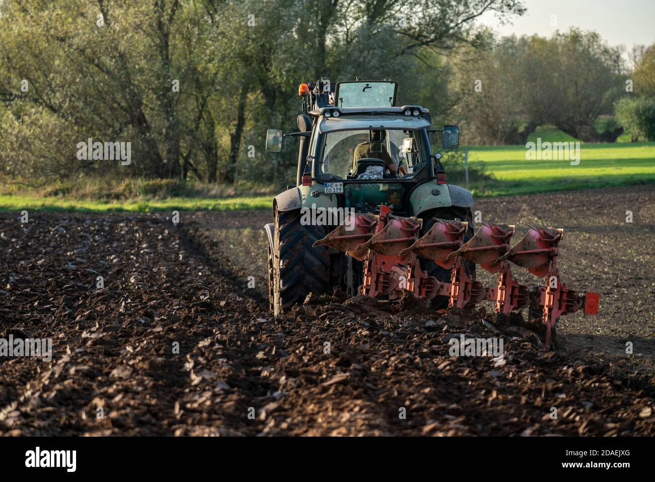 Landwirt pflügt einen Acker, Trecker mit Pflug, bei  Neuss, NRW, Deutschland, Stock Photo