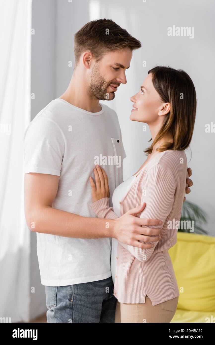 happy man and woman looking at each other while hugging at home Stock Photo
