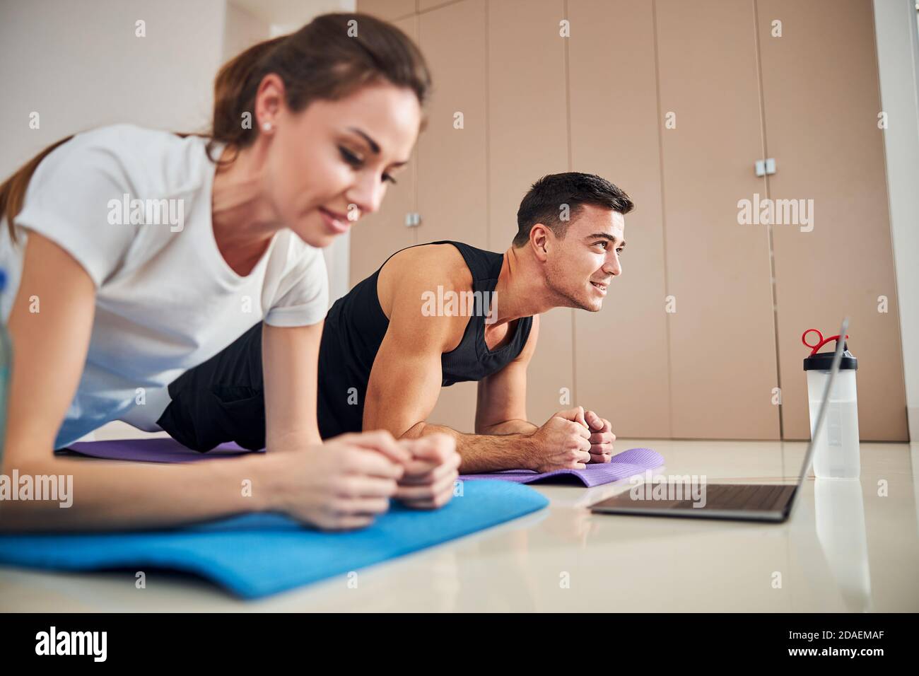 Fit couple standing in plank position while working out Stock Photo