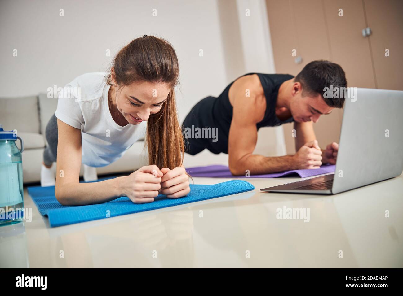 Fit couple exercising at home during a lockdown Stock Photo