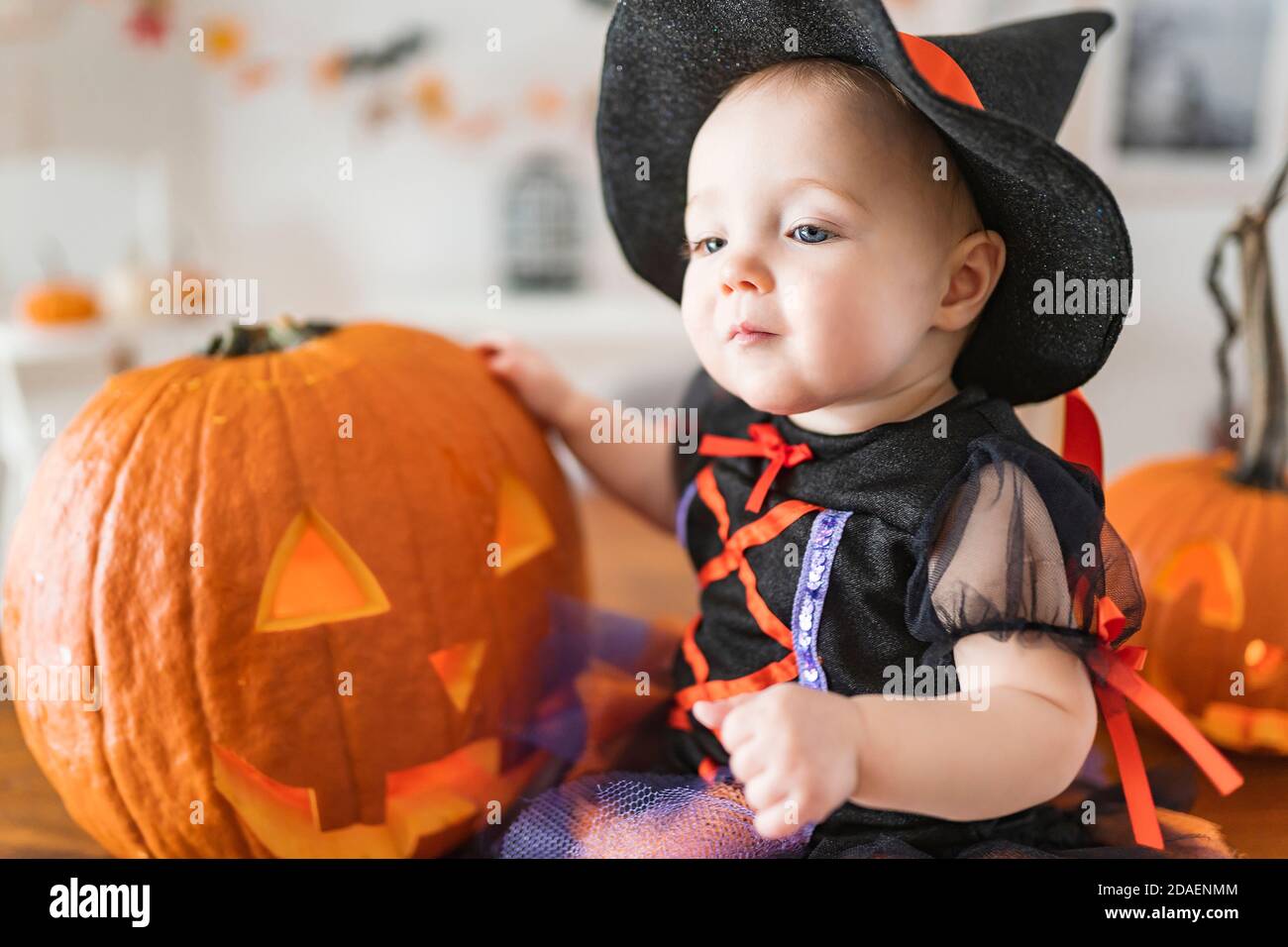 Beautiful Baby Girl In Witch Halloween Costume At Home Kitchen Table Stock Photo Alamy