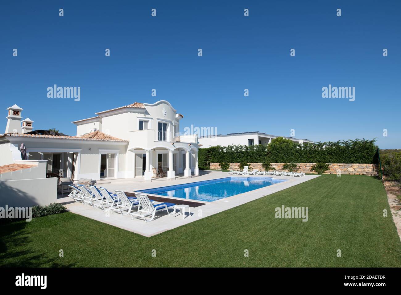 Exterior of luxury Holiday Villa with blue sky and beautiful swimming pool Stock Photo