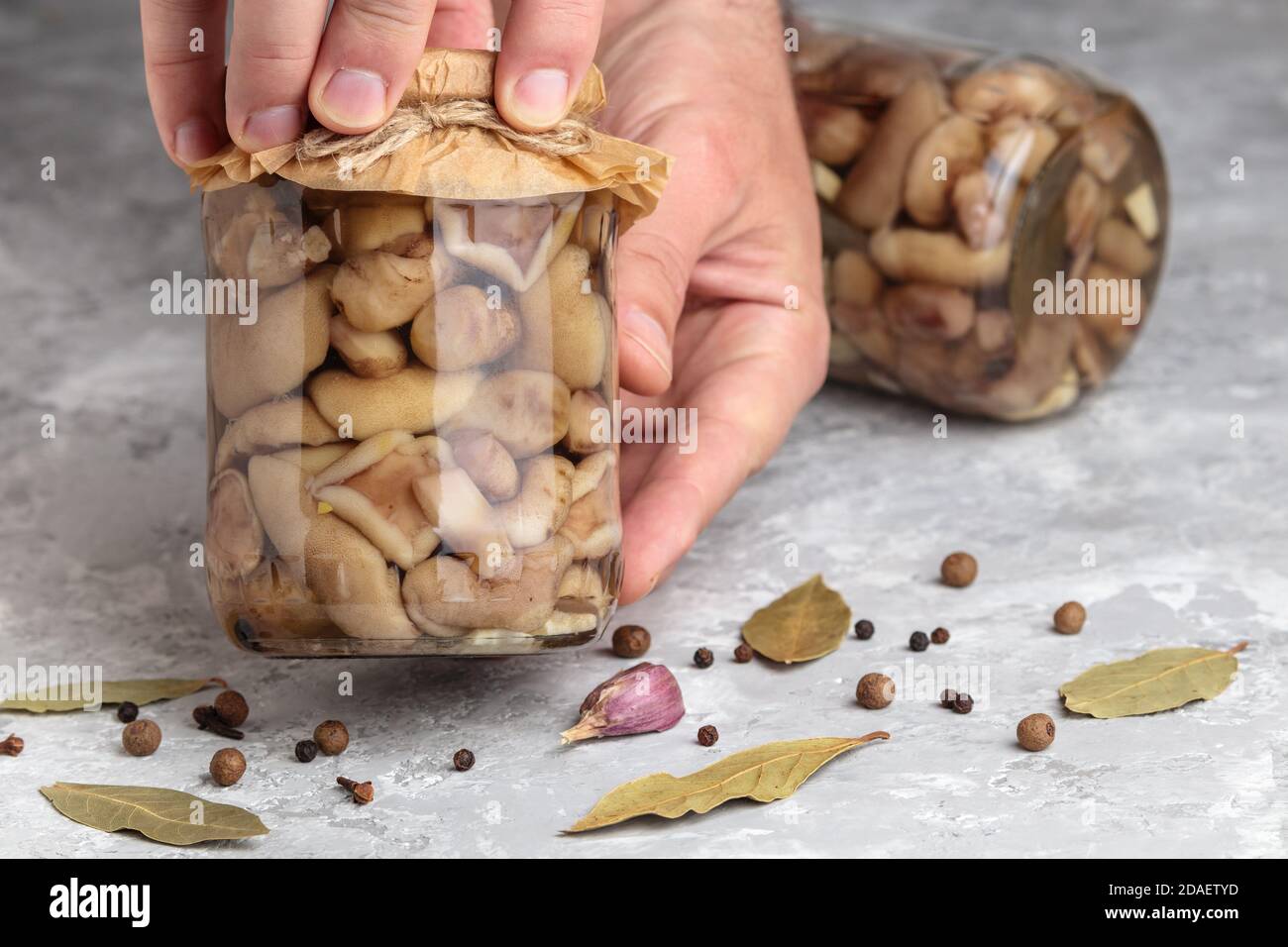 Marinated mushroom. Canned mushrooms jar in hands. Delicious pickled