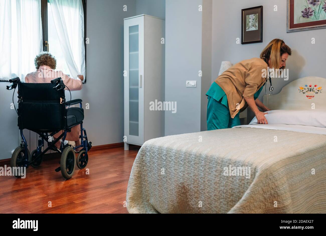 Nurse making bed elderly woman hires stock photography and images Alamy