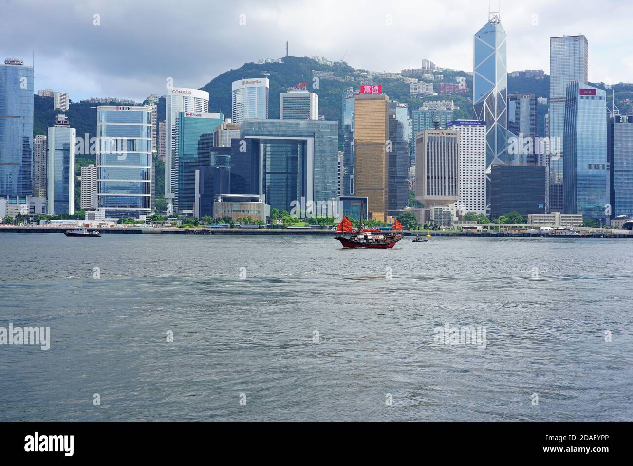 HONG KONG -29 JUN 2019- A Chinese junk ship passes in the Victoria harbor in front of the modern Hong Kong skyline. Stock Photo
