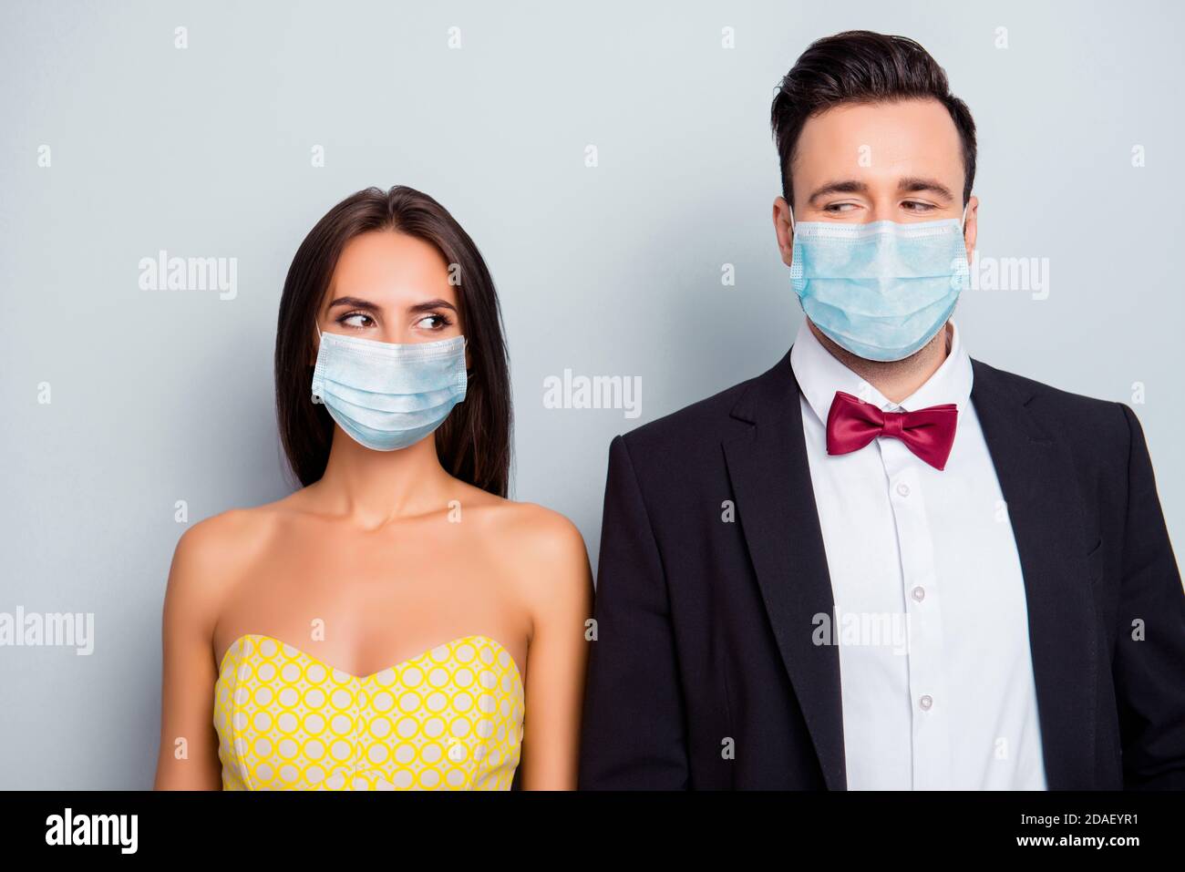 Photo portait of couple wearing blue face masks looking at each other isolated on white colored background Stock Photo