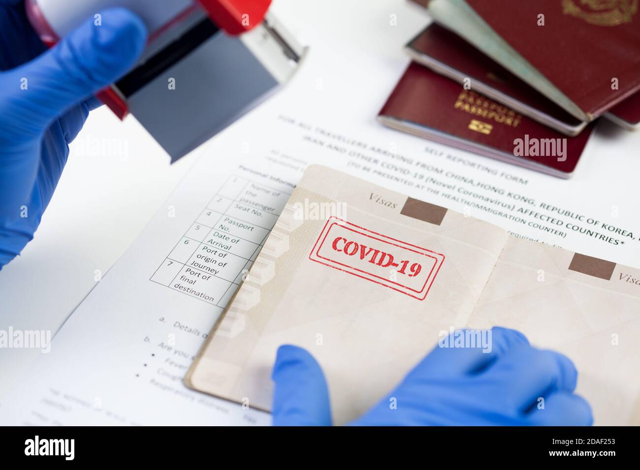 COVID-19 stamped in passport,airport border customs health and safety security check,restrictive no entry measures due to COVID-19 corona virus diseas Stock Photo