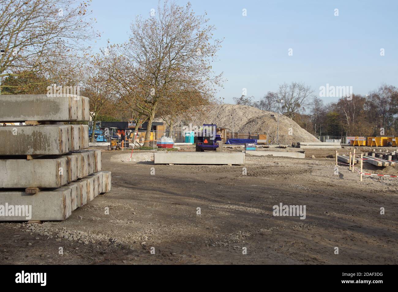 A Dutch construction site with square concrete piles, an excavator and