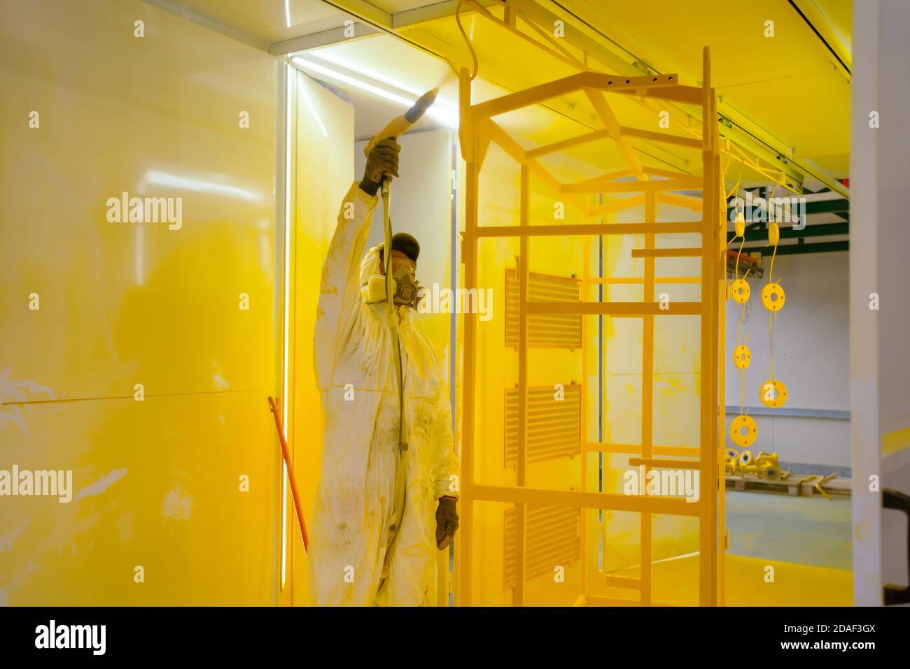 Construction worker spraying paint to steel pipe to prevent the rust on the surface Stock Photo
