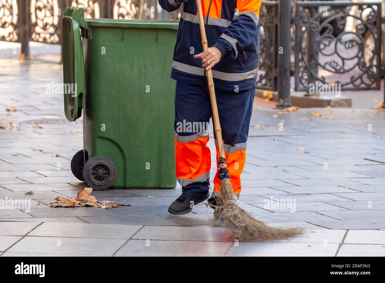 Janitor works in the street with a broom Stock Photo