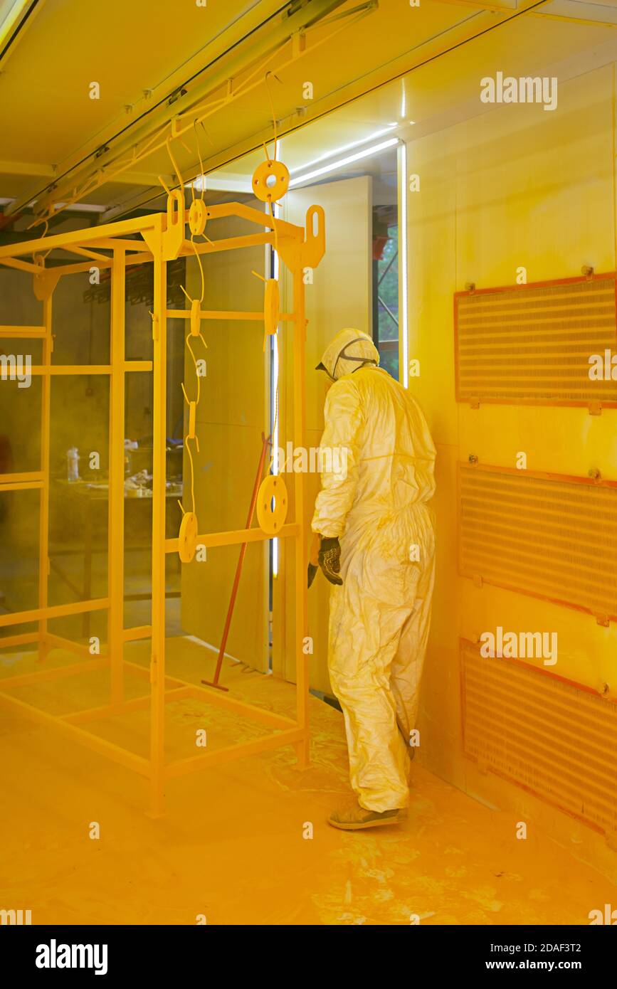 Construction worker spraying paint to steel pipe to prevent the rust on