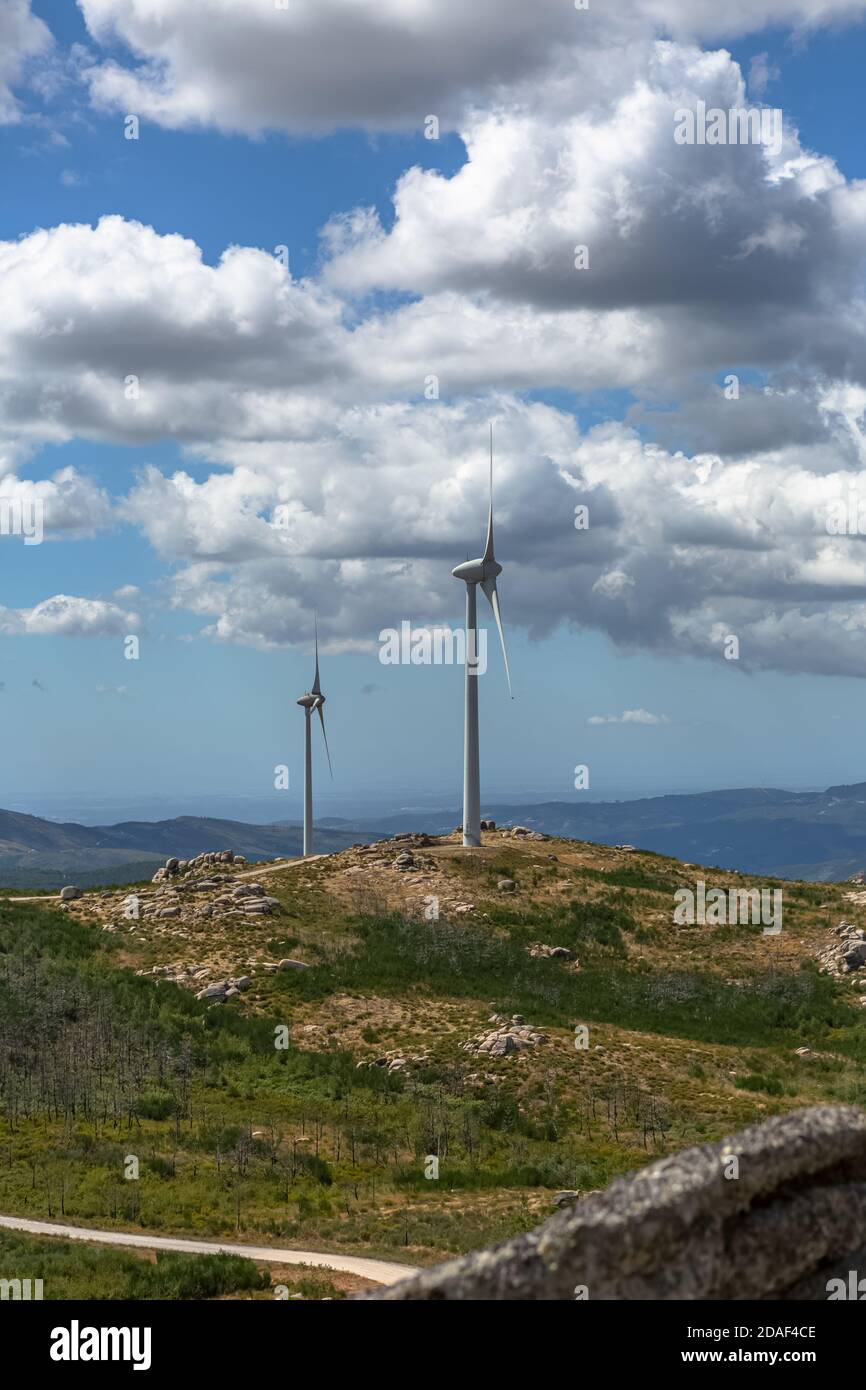 View of a wind turbines on top of mountains, cloudy sky as background ...