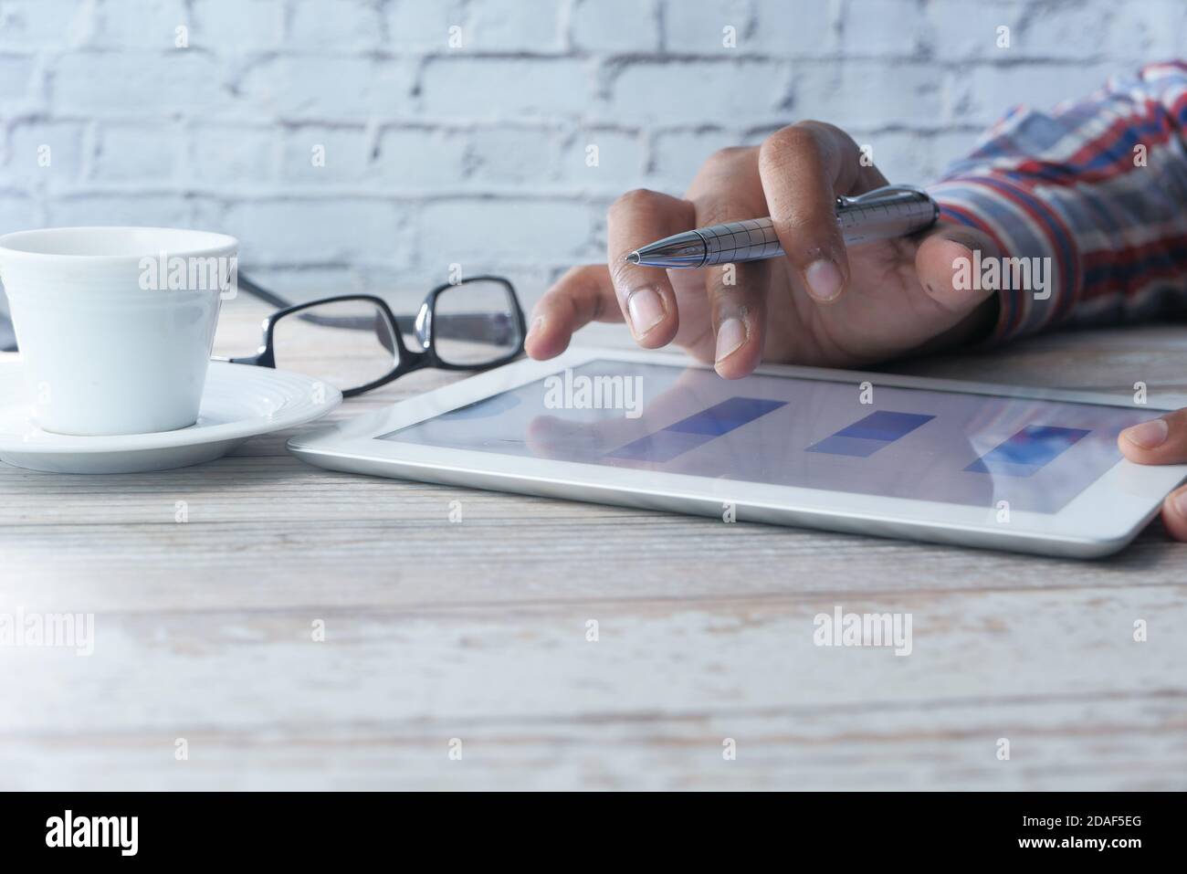 man's hand working on digital tablet at office desk, using self created ...