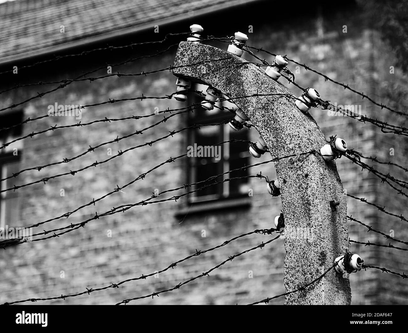 old barbed wire that marks the start of a concentration camp used during World War II with black and white toned effect Stock Photo