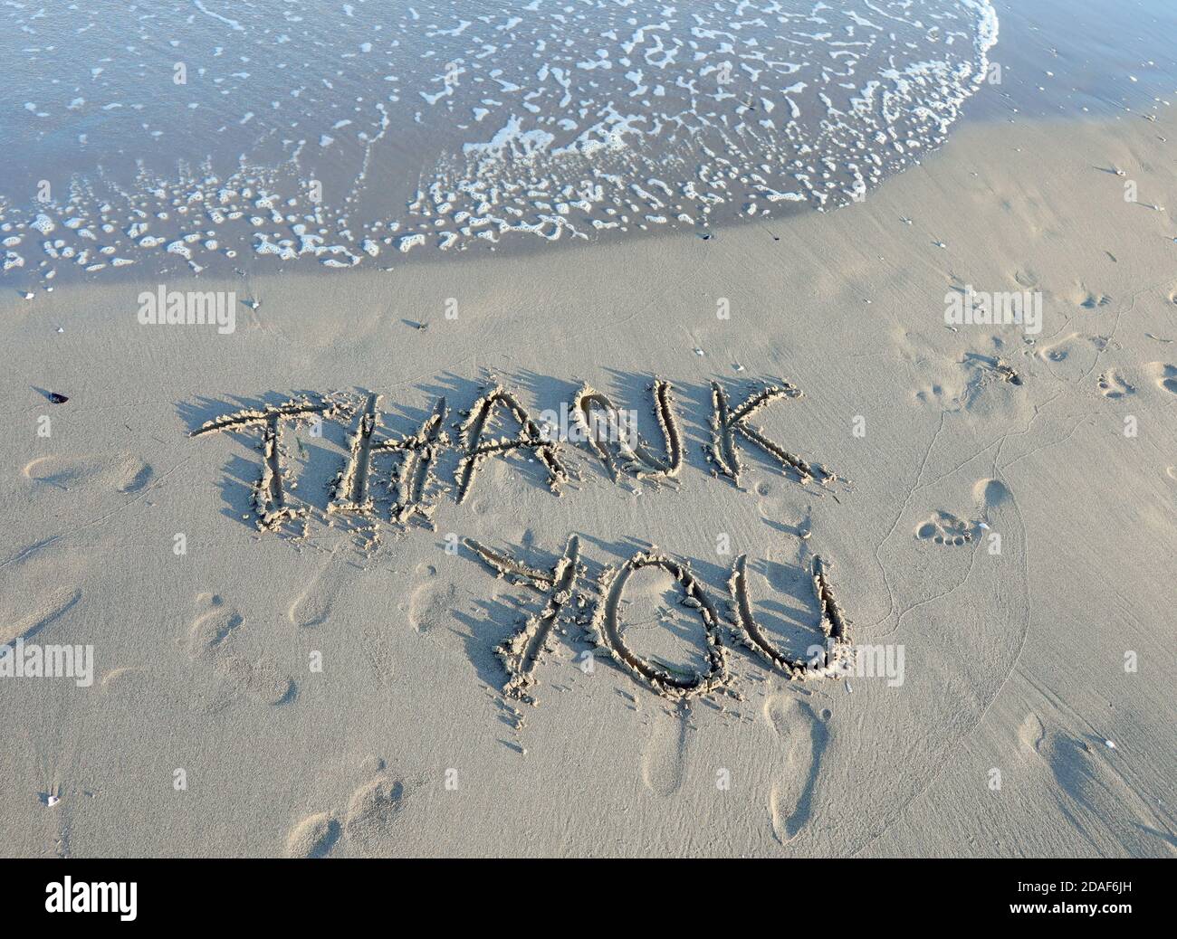 THANK YOU text written on the sand of the beach by the sea Stock Photo ...