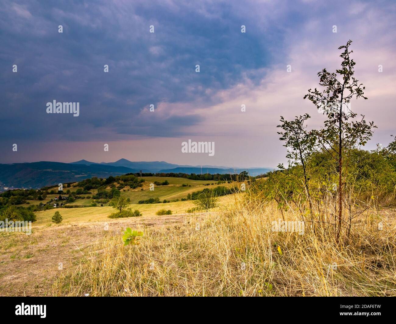 Dark heavy rain clouds coming over a hilly landscape Stock Photo - Alamy