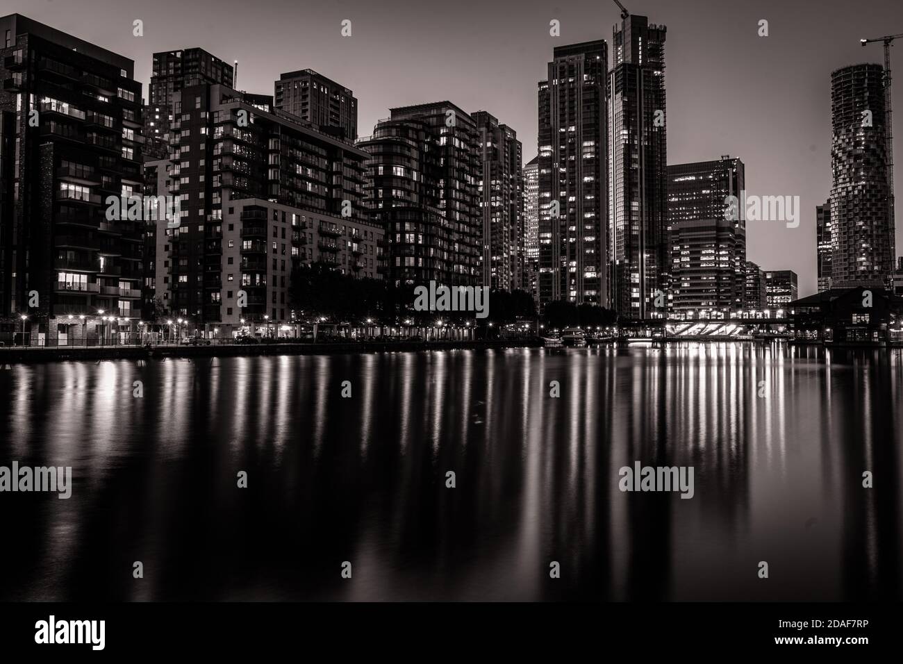 Tall buildings at night time with lights reflexions on the water Stock Photo
