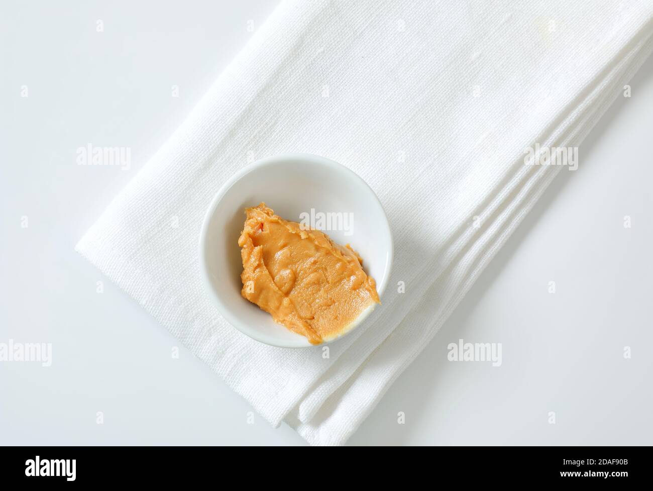 Bowl of crunchy peanut butter on white napkin Stock Photo