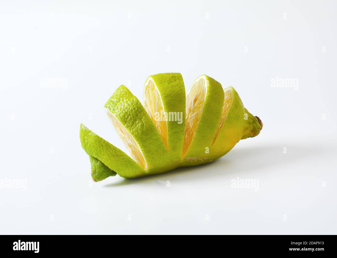 Lemon with green peel and yellow flesh, sliced Stock Photo