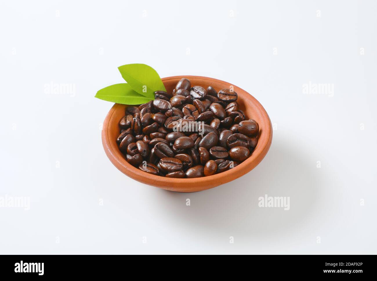 Roasted coffee beans in terracotta bowl Stock Photo