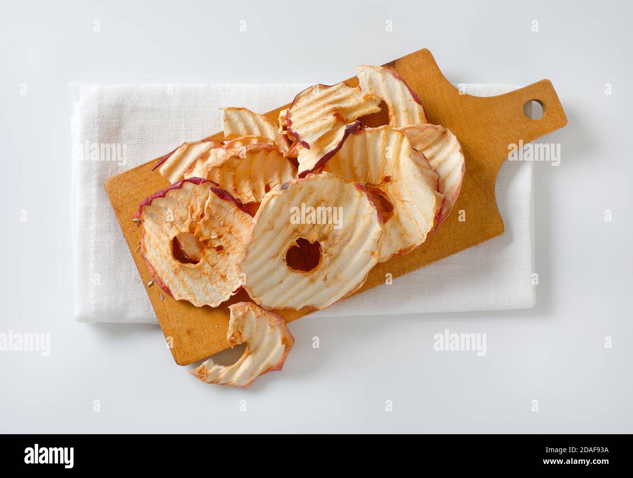 Dried apple chips or rings on cutting board Stock Photo