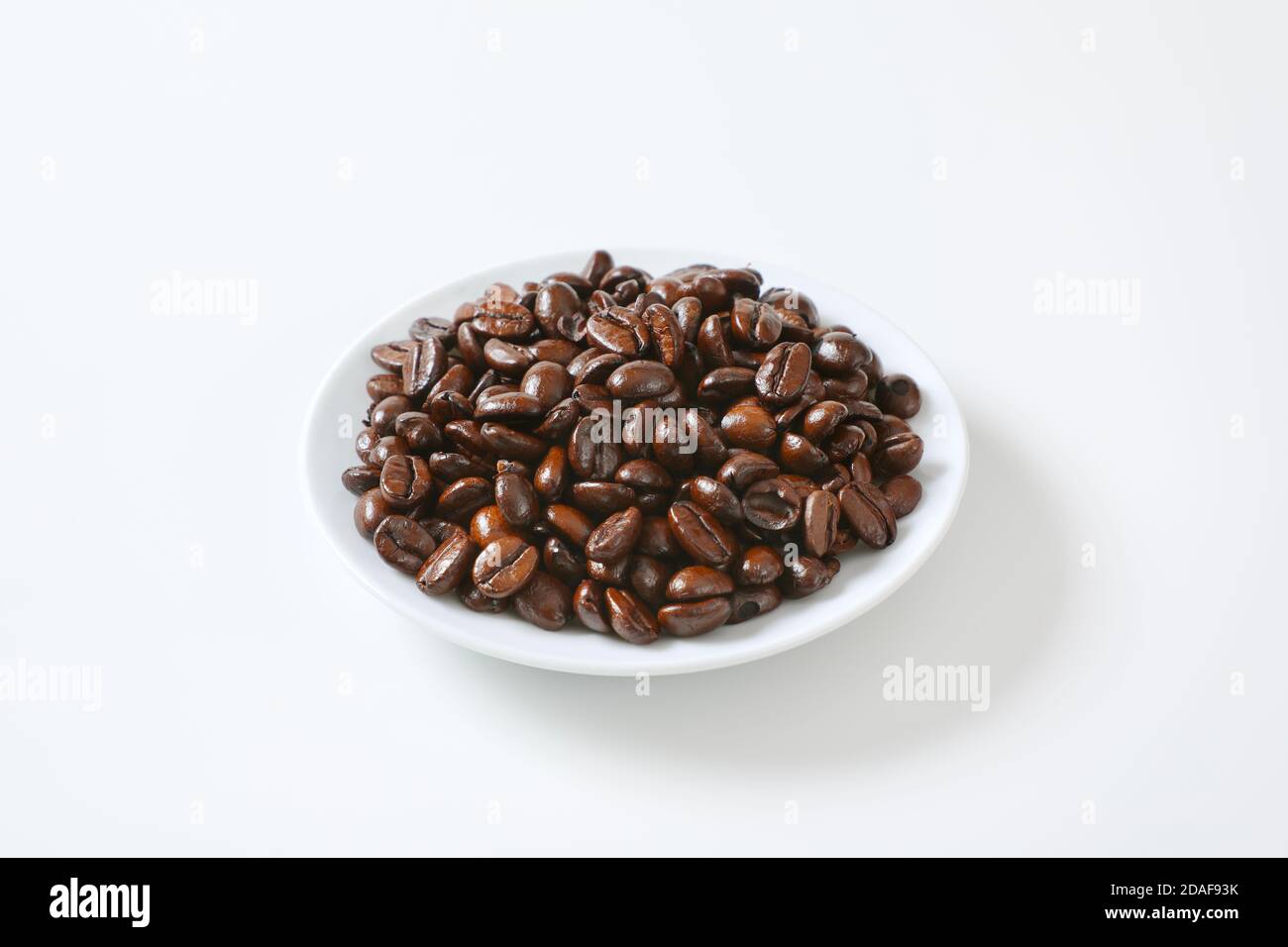 Roasted coffee beans on white plate Stock Photo
