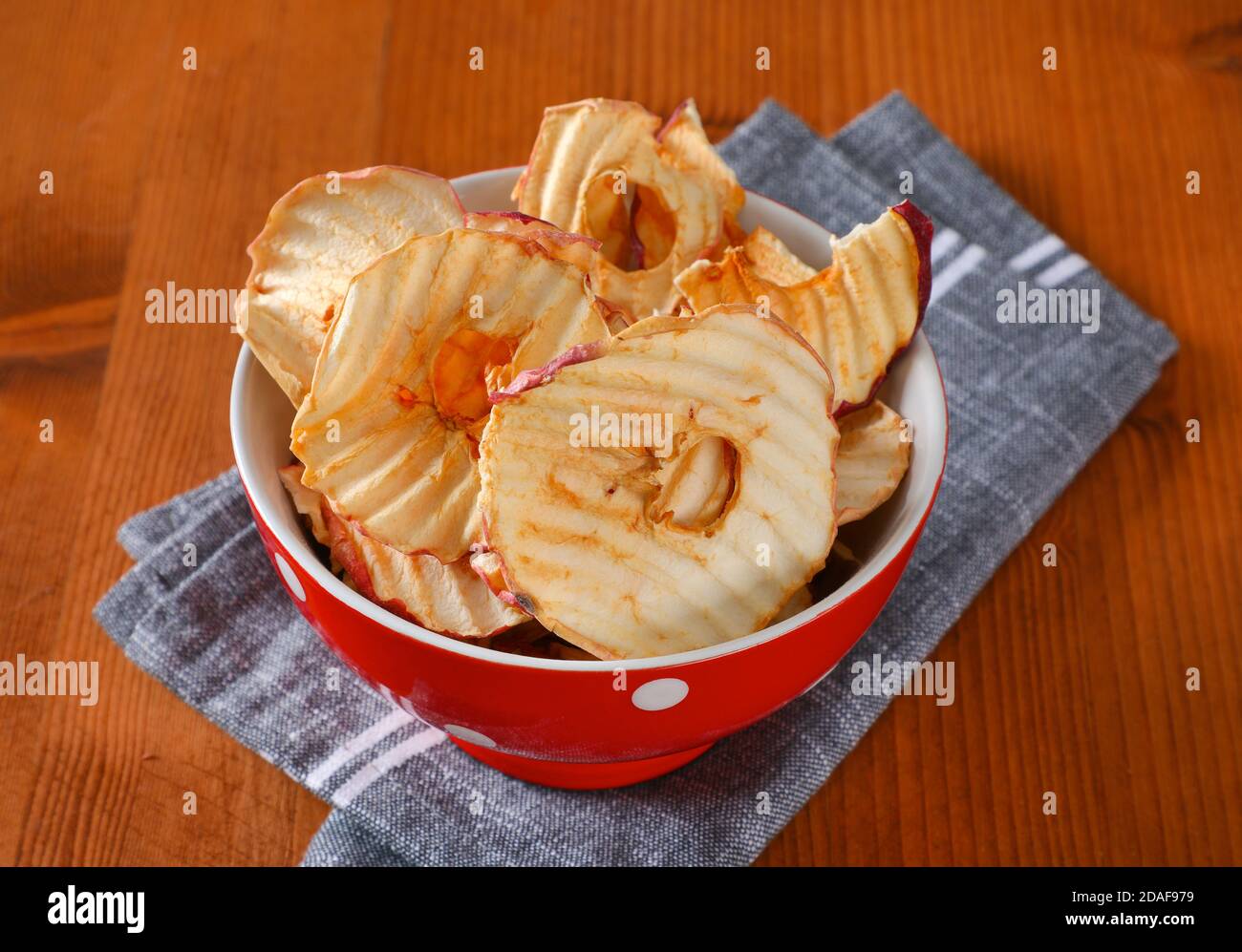Bowl of dried apple slices - apple chips or rings - on gray napkin Stock Photo