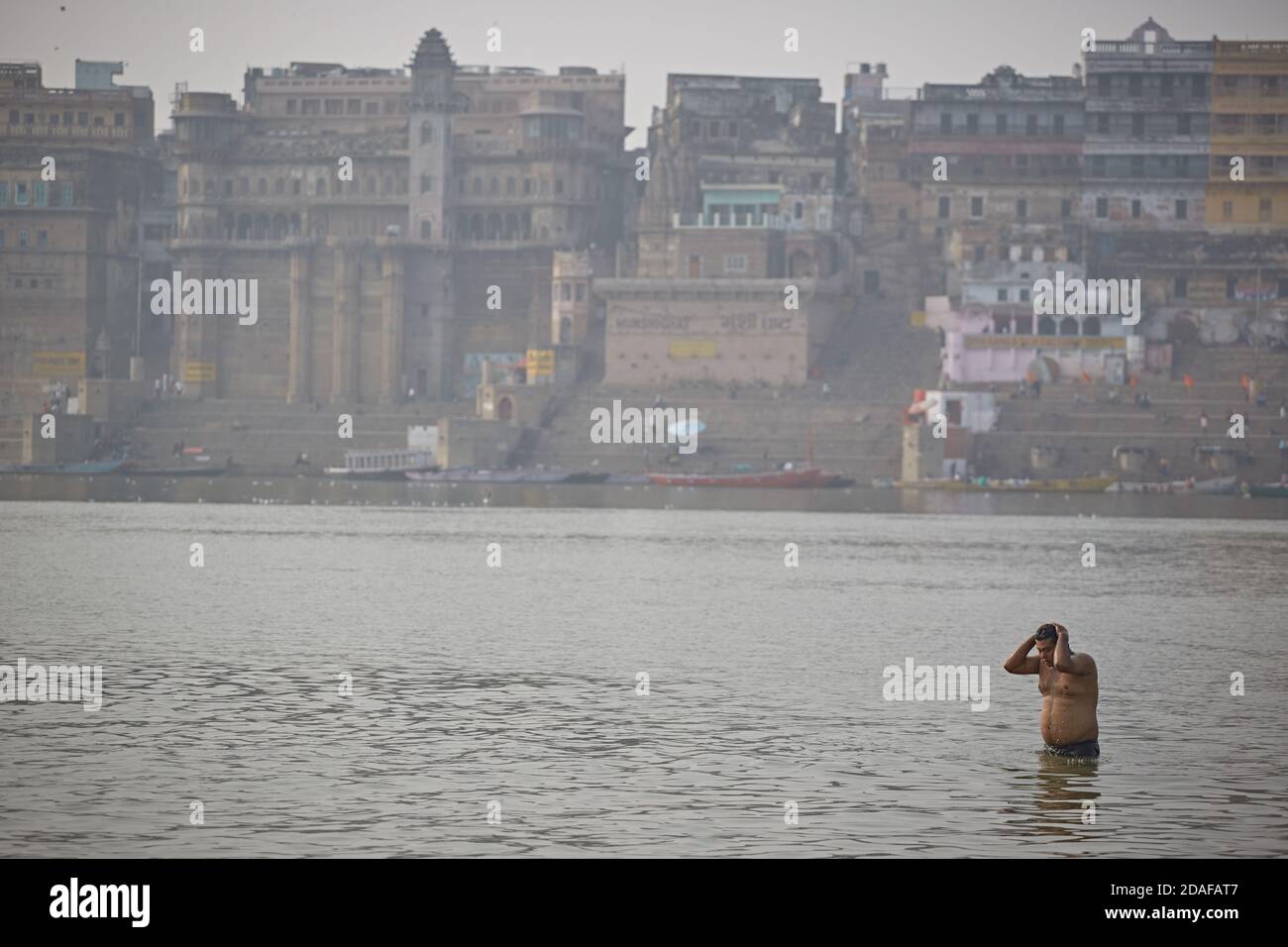 Varanasi, India, December 2015. A person doing a ritual bath in the ...