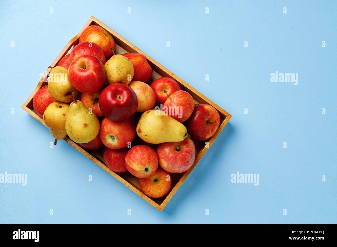 Wooden box with apples and pears on blue background Stock Photo - Alamy